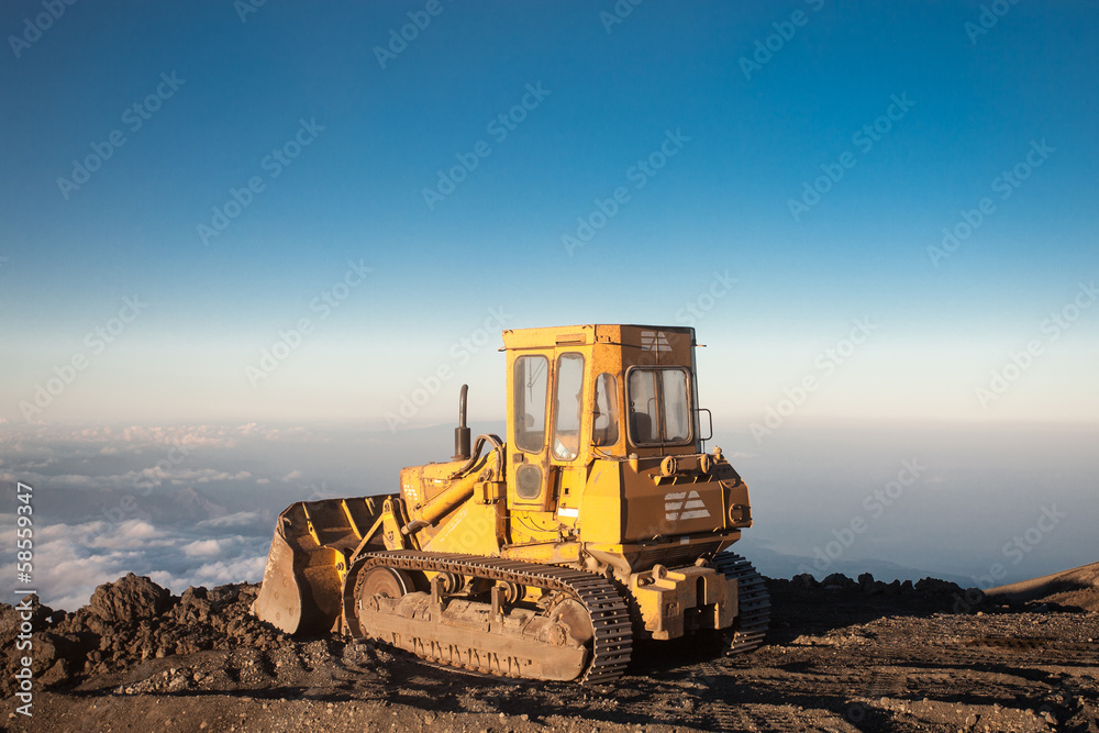 Yellow tractor at the top of the Etna mountain with view on the Yellow tractor at the top of the Etna mountain with view on the