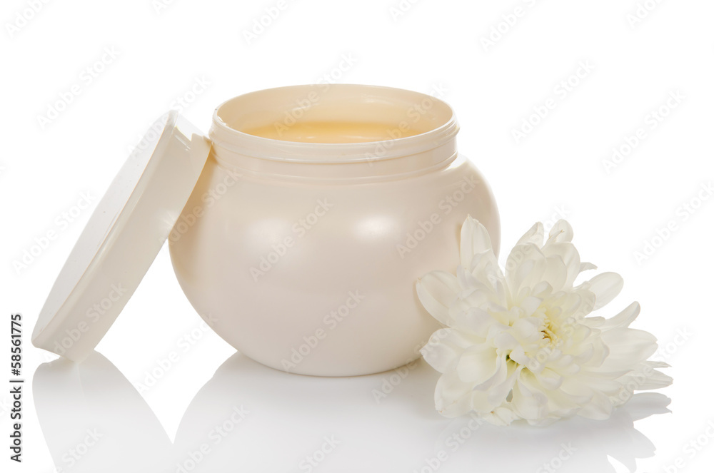 Open jar with a face cream and flower