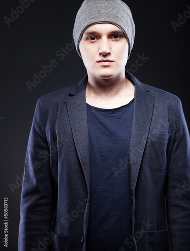 Portrait of casual young man wearing jacket and cap