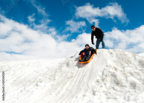 Boy and dad sledding in winter
