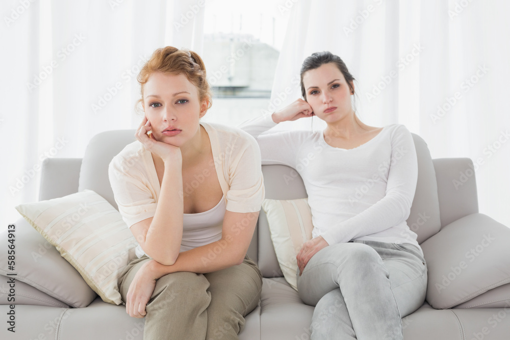 Unhappy friends not talking after argument on the couch Unhappy friends not talking after argument on the couch
