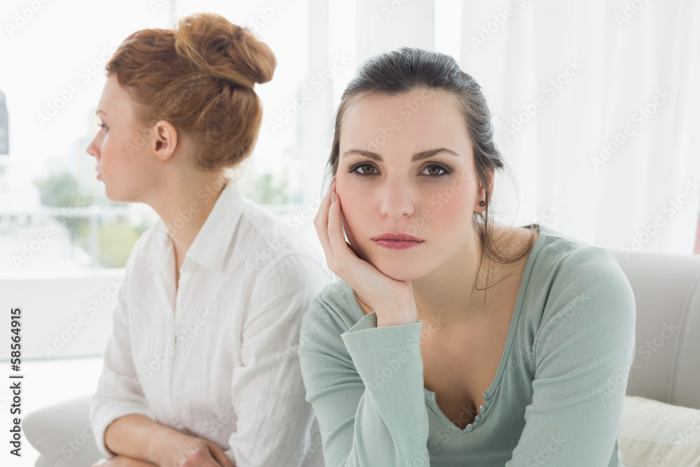 Unhappy friends not talking after argument on the couch Unhappy friends not talking after argument on the couch