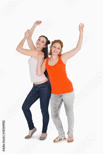 Portrait of two cheerful young female friends dancing