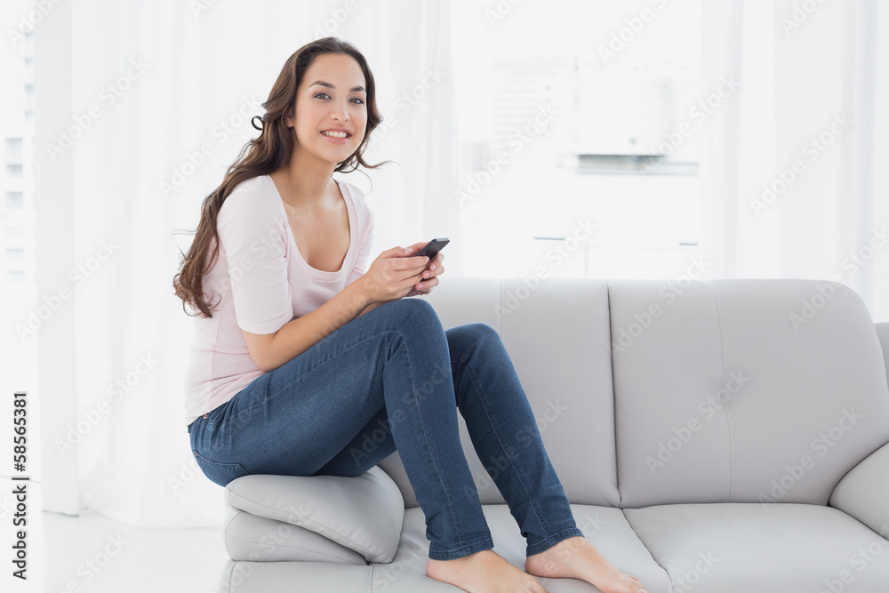 Relaxed woman text messaging on sofa at home Relaxed woman text messaging on sofa at home