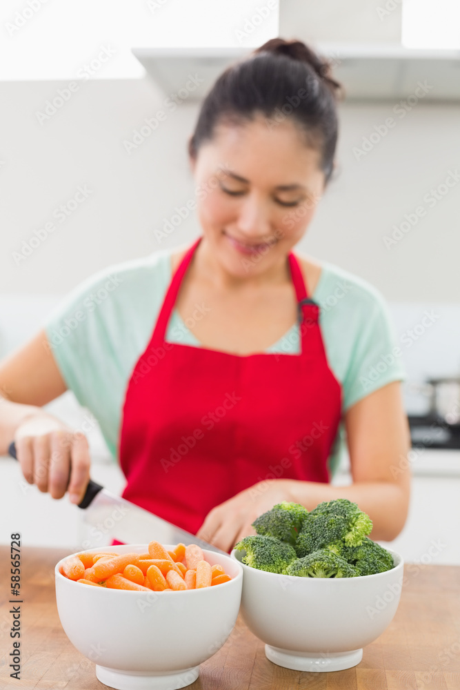 Smiling young woman chopping vegetables in kitchen Smiling young woman chopping vegetables in kitchen