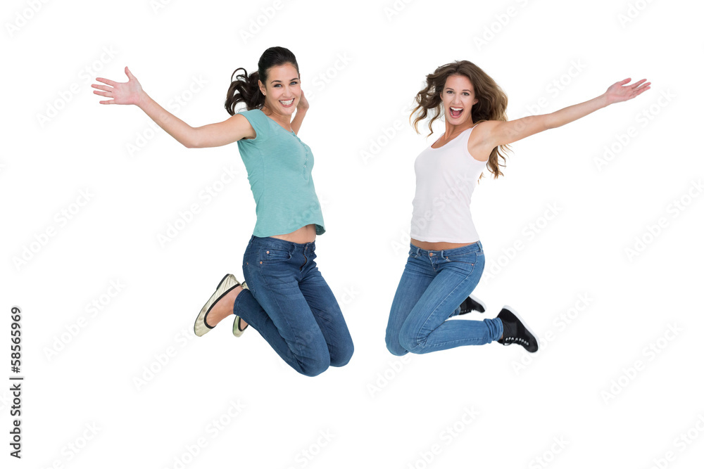 Two cheerful young female friends jumping Two cheerful young female friends jumping