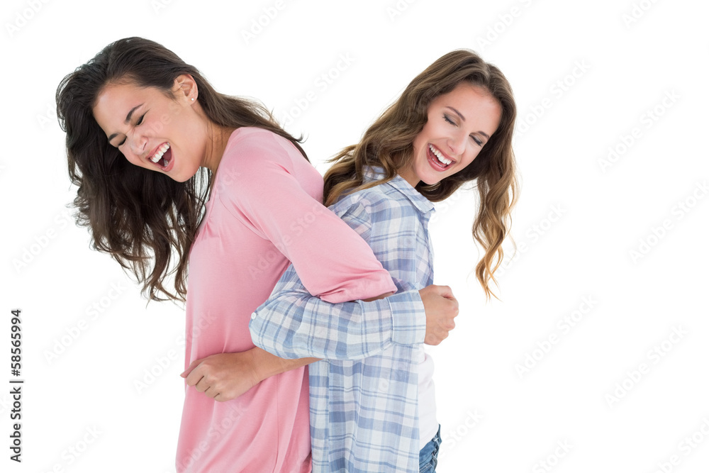 Women standing back to back with interlocked hands Women standing back to back with interlocked hands