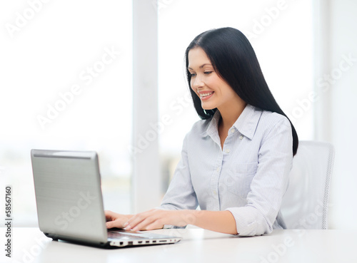 smiling businesswoman or student with laptop photo