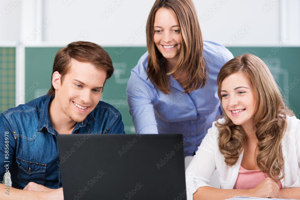 lehrerin und schüler schauen auf laptop