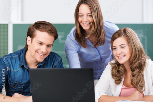 lehrerin und schüler schauen auf laptop