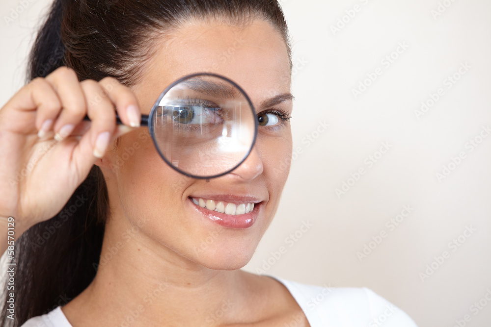 woman looking through a magnifying glass woman looking through a magnifying glass