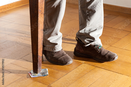 legs of a man under the table, parquet floor photo