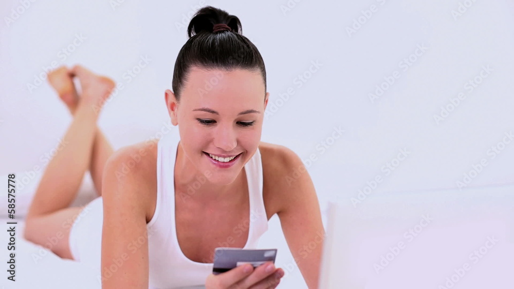 Gleeful woman home shopping using her notebook Gleeful woman home shopping using her notebook