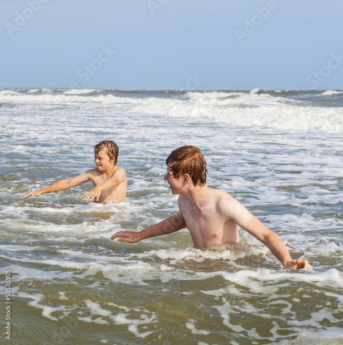 boys enjoying the waves in the wild ocean