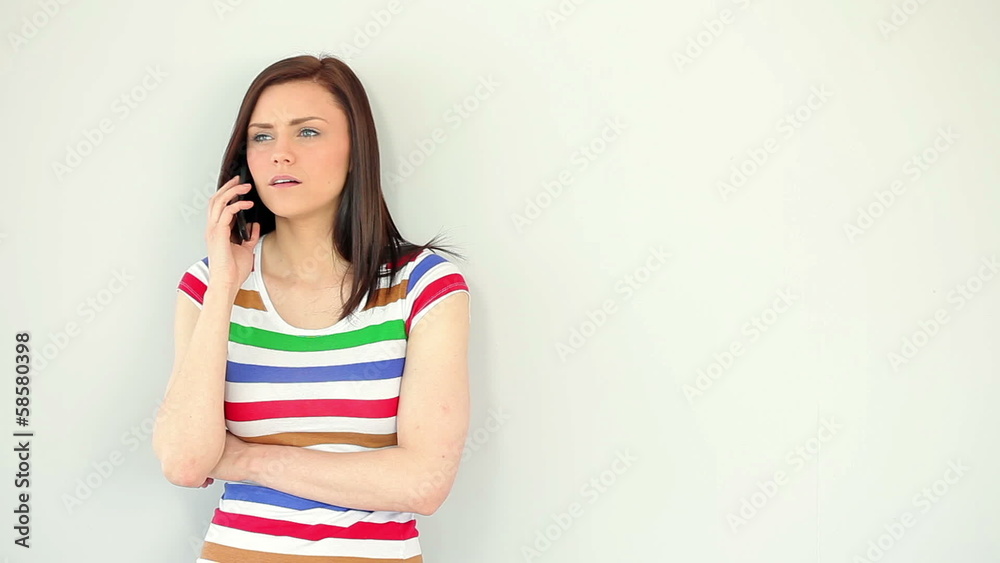 Annoyed young woman talking on her phone