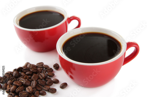 Red cups of strong coffee and coffee beans close up