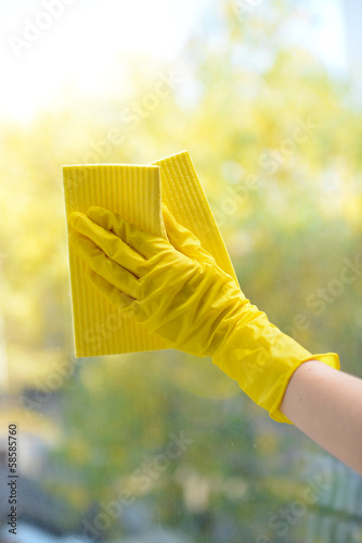 Hands with napkin cleaning window