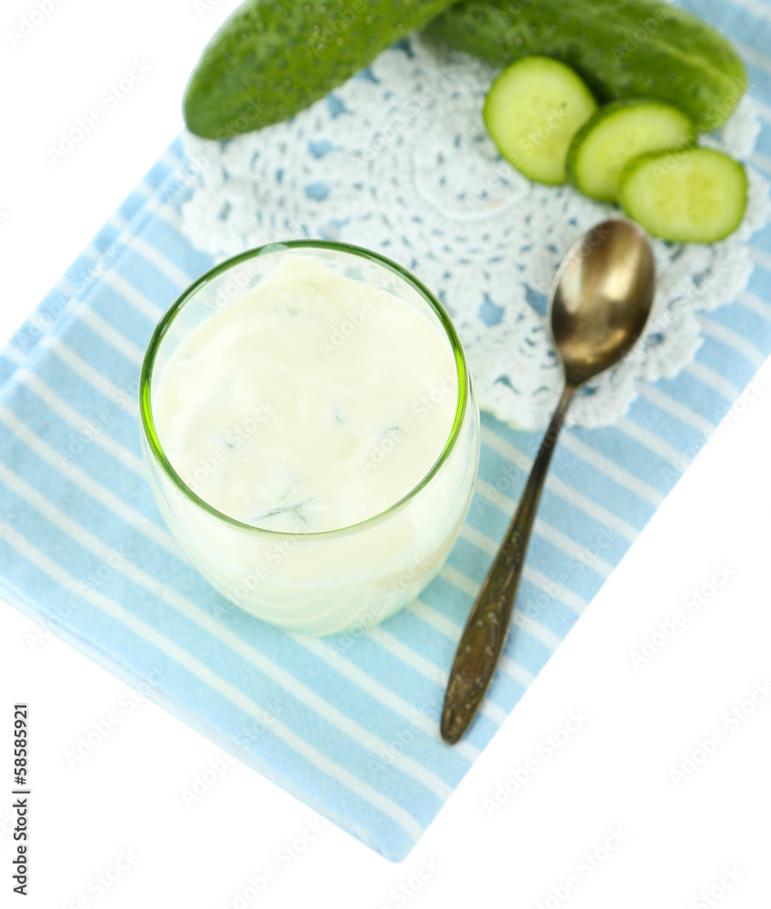 Cucumber yogurt in glass, on color napkin, isolated on white Cucumber yogurt in glass, on color napkin, isolated on white