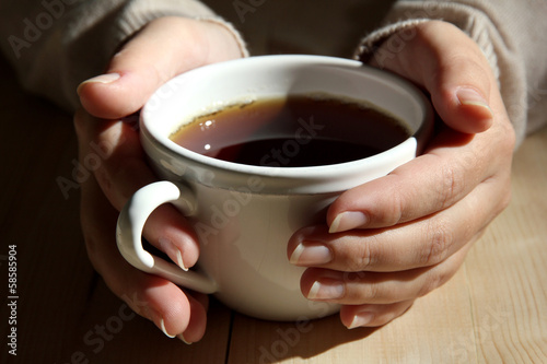 Hands holding mug of hot drink, close-up