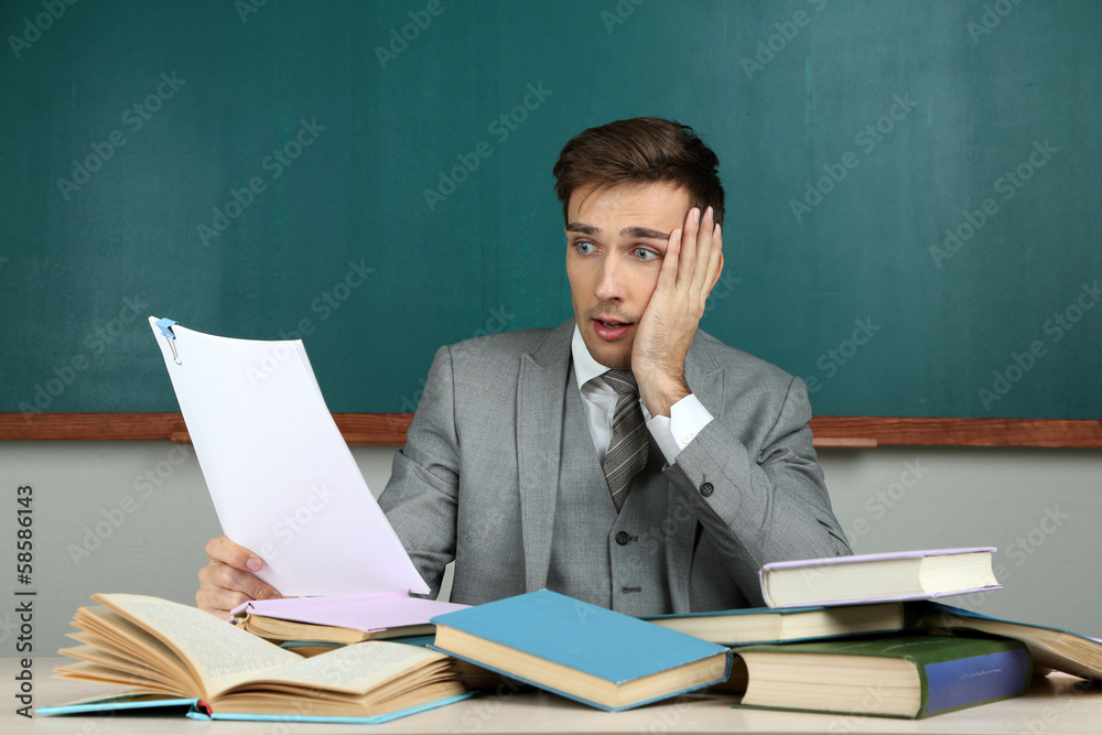 Young teacher sitting in school classroom Young teacher sitting in school classroom