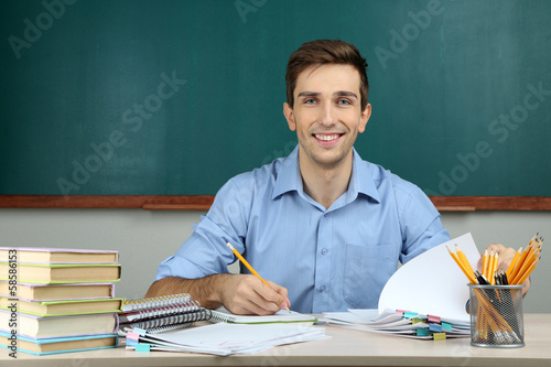 Foto Young teacher working in school classroom