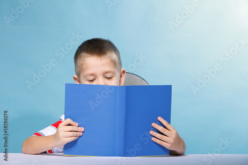 child boy kid reading a book on blue