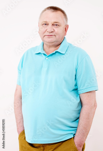 Senior man with hands in pockets over white