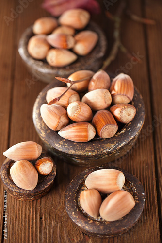 wild hazelnut in iron bowls on wooden table