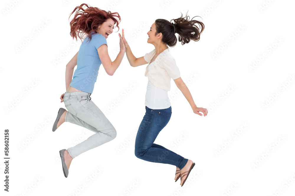 Happy young female friends playing clapping game
