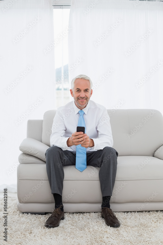 Elegant mature businessman text messaging at home Elegant mature businessman text messaging at home