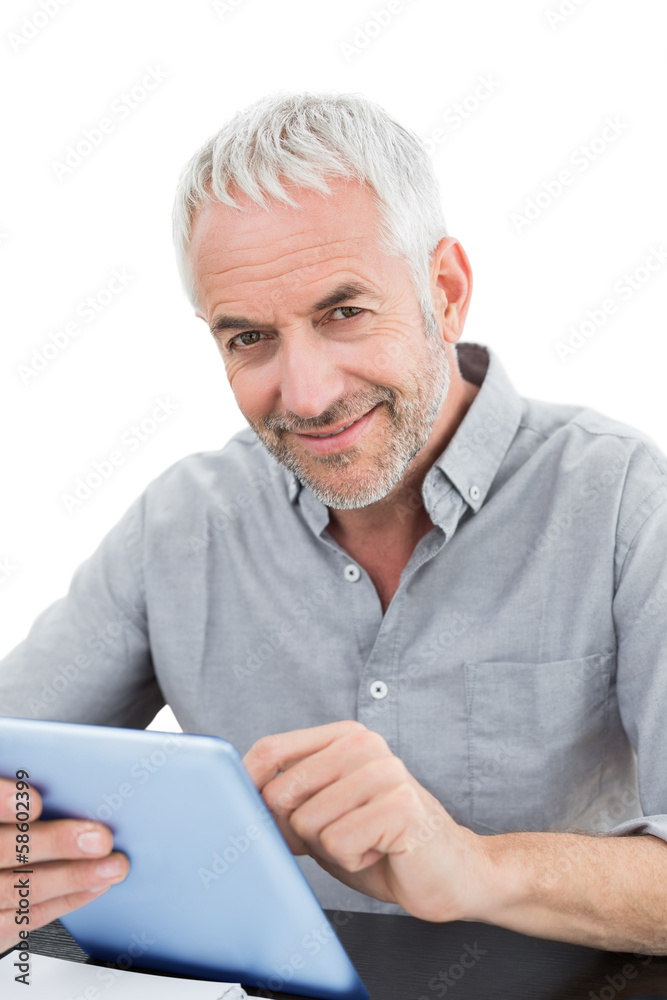 Portrait of a smiling mature businessman using digital tablet