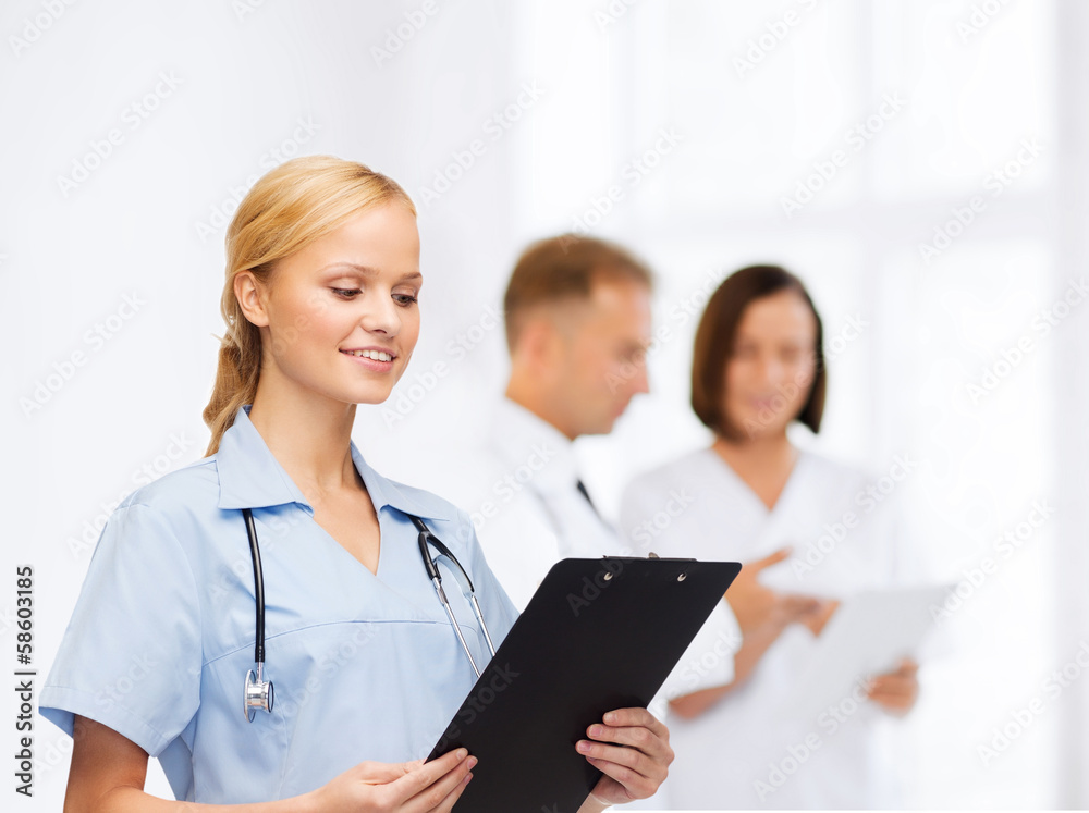 smiling female doctor or nurse with clipboard smiling female doctor or nurse with clipboard