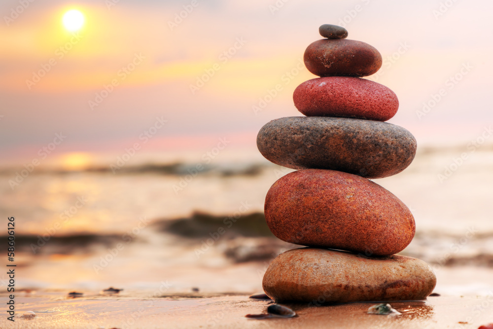 Fototapeta premium Piramida z kamieni na piasku symbolizująca zen, harmonię, równowagę