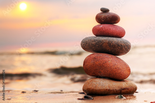 Canvas Print Stones pyramid on sand symbolizing zen, harmony, balance