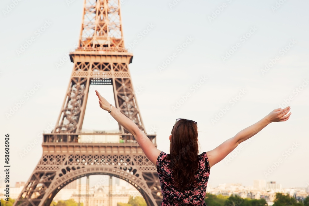 Young happy woman facing the Eiffel Tower, Paris, France