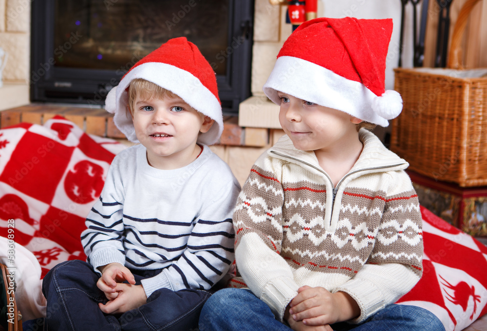 Fototapeta premium Two little sibling boys being happy about christmas present