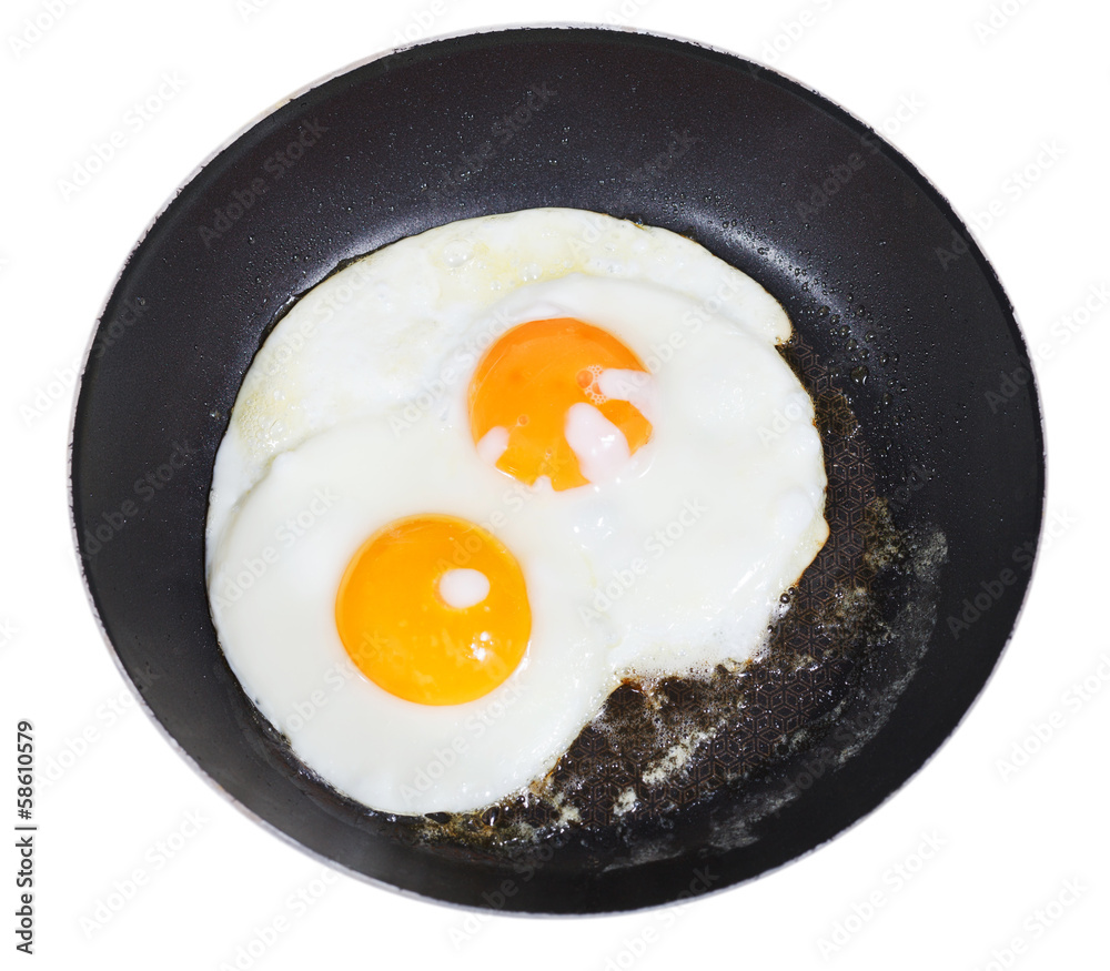 top view of fried eggs in pan isolated on white top view of fried eggs in pan isolated on white