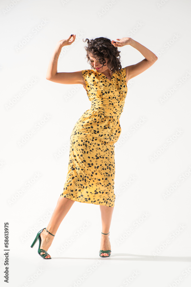 Naklejka premium Beautiful girl in a yellow dress dancing