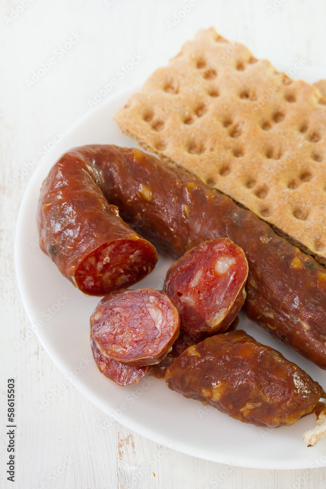sausage with toasts on white plate