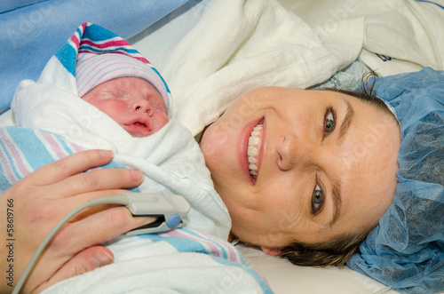 Mother hugs her new infant after delivering child by c-section photo