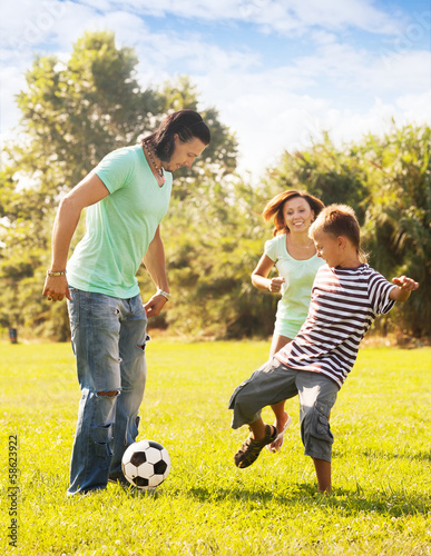 Happy parents with teenage son playing with ball