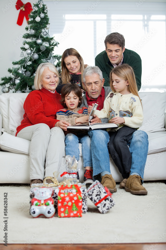 Family Looking At Book In House Family Looking At Book In House