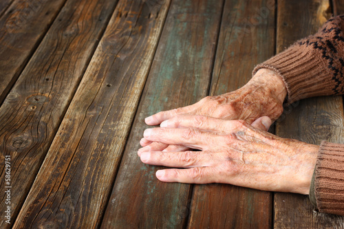 close up of elderly male hands on wooden table