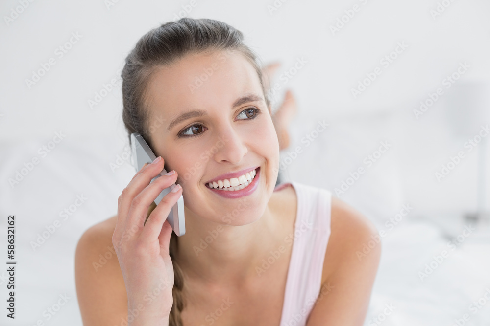 Beautiful smiling woman using cellphone in bed Beautiful smiling woman using cellphone in bed