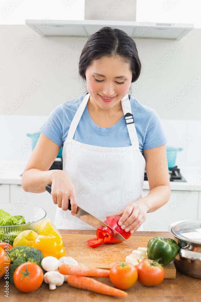 Smiling woman chopping vegetables in kitchen Smiling woman chopping vegetables in kitchen
