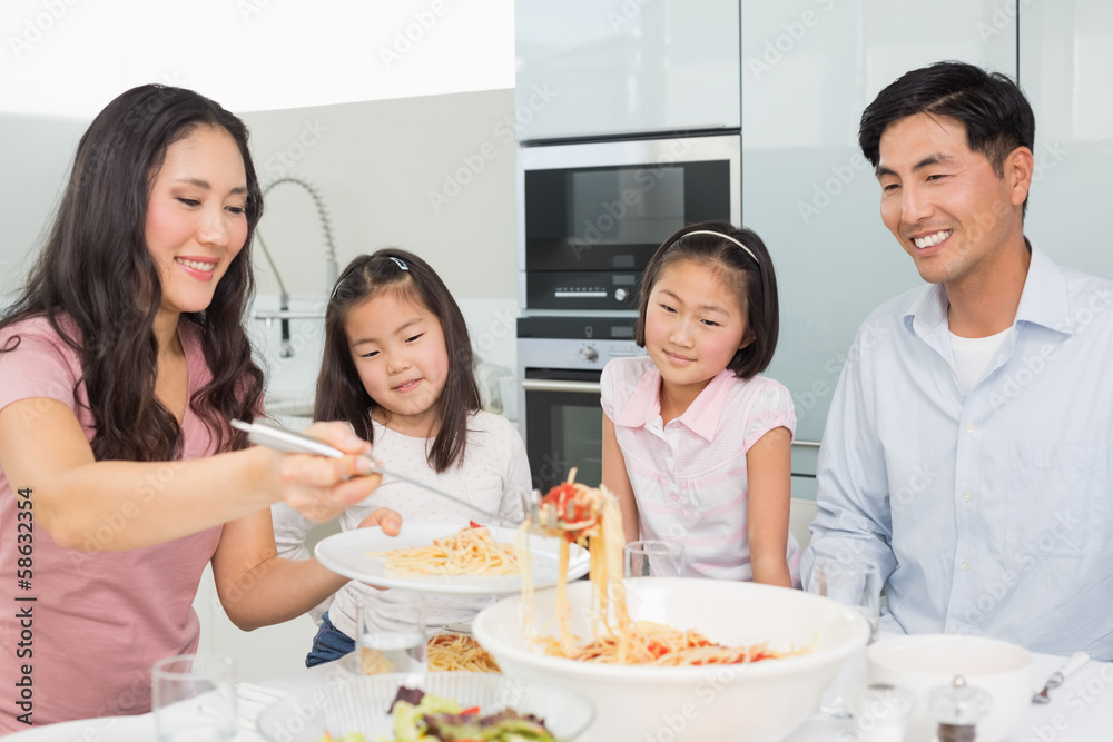 Woman serving food for the family in kitchen Woman serving food for the family in kitchen