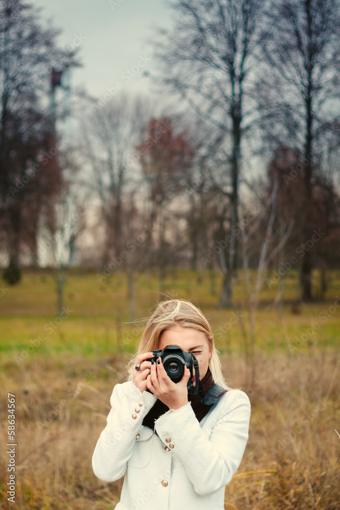 young woman with camera outdoors at the park