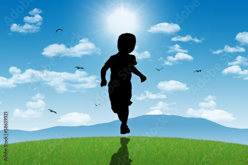 little boy running towards shining sun