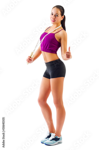 Young sporty girl with skipping rope shows ok gesture