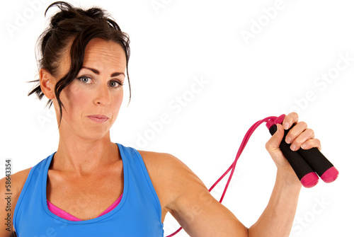 Woman with jump rope and workout clothes looking at camera